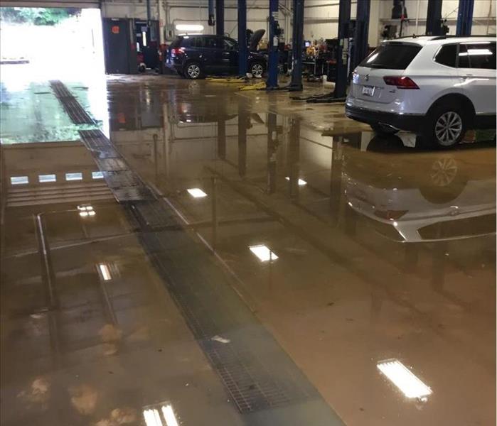 water flooding in a garage with cars